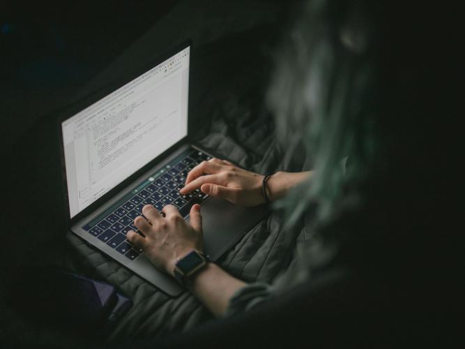 Image of individual typing on laptop