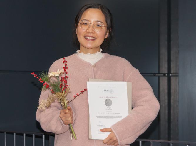 Xinyi Zhao holds the certificate of her award from the Max Planck Institute for Demographic Research
