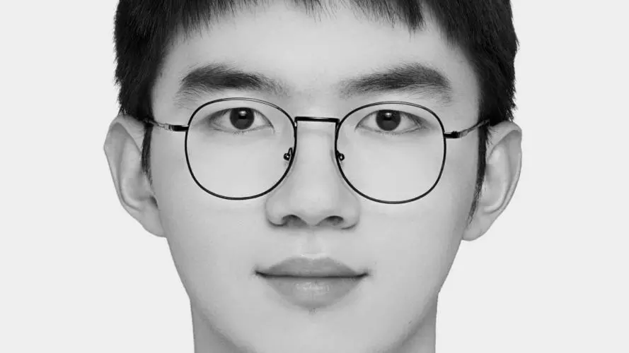 Jianghao Zhu has short black hair and glasses. He is wearing a dark suit, white shirt and tie