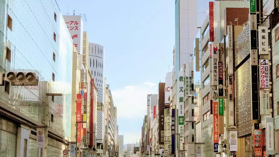 Crowds of people walk down a street in Tokyo