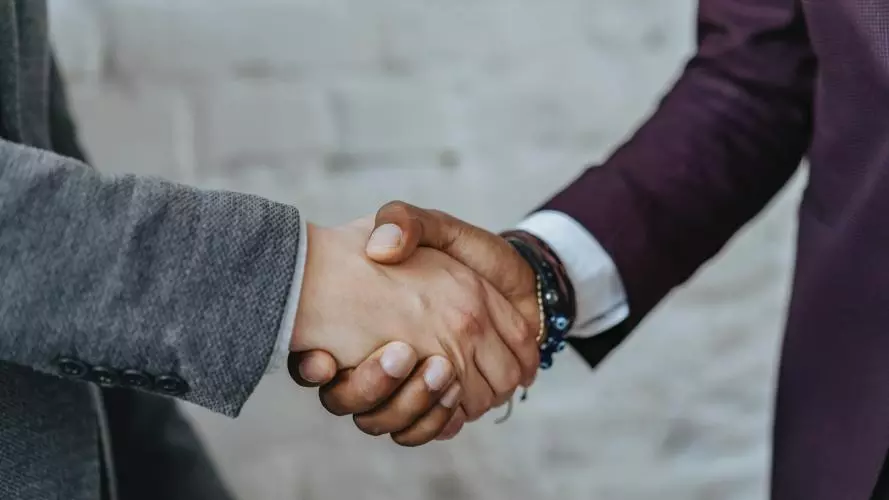 Two people shake hands