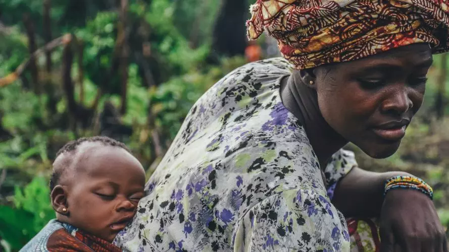 Image of a woman carrying a baby on her back