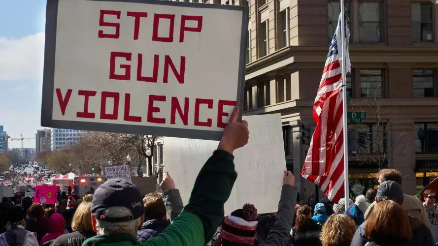 A man holds a sign saying 'stop gun violence' during a protest