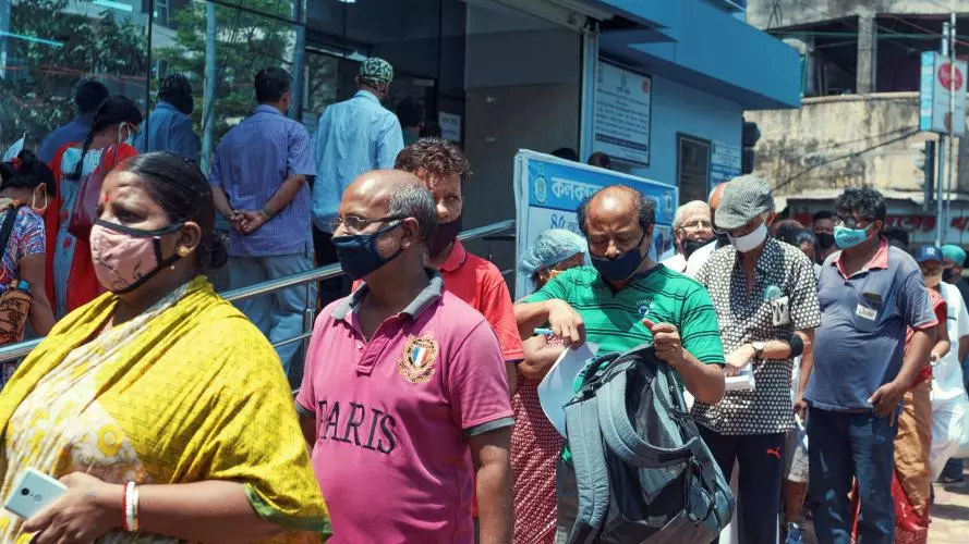 People waiting in long queues outside a Kolkata community health clinic, waiting for the covid-19 vaccine.