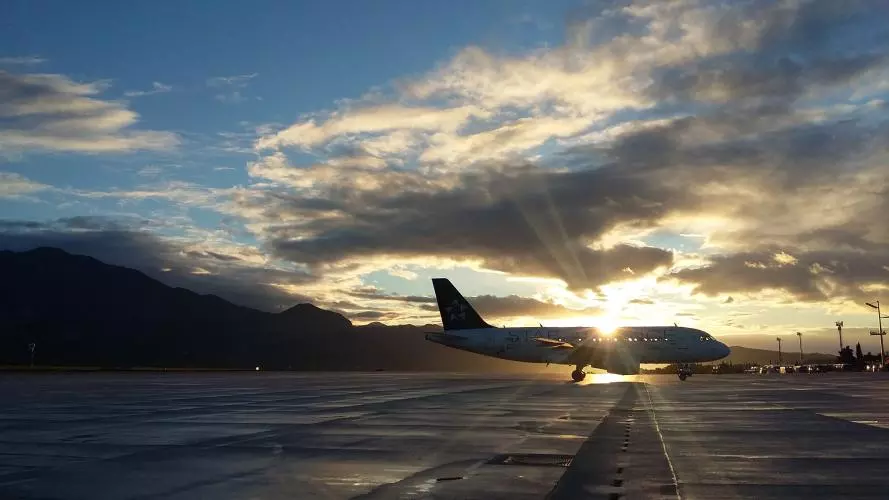 An image of a plane on a runway during sunset