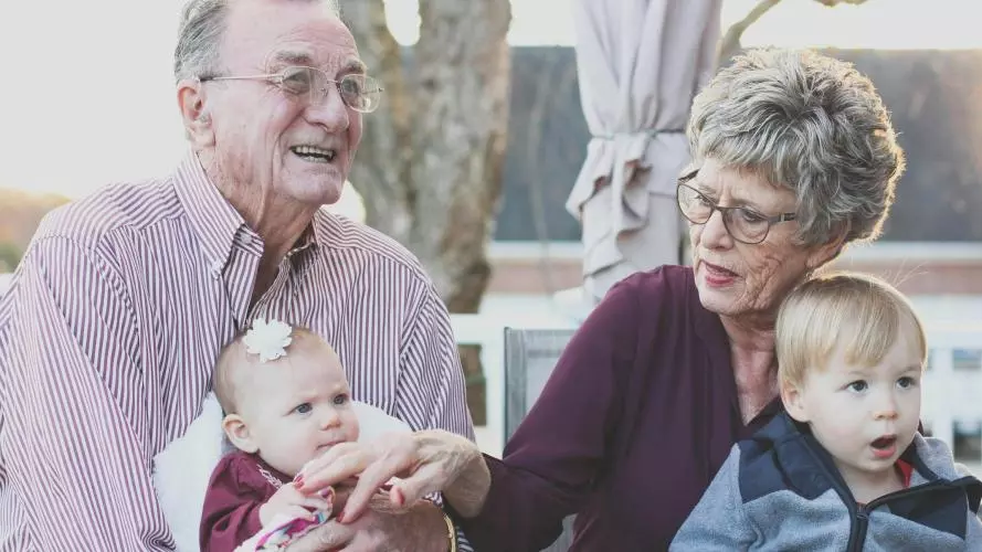 Image of an elderly couple sitting with their two young grandchildren 