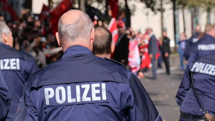 The Polizei, German police officers, walk away from the camera
