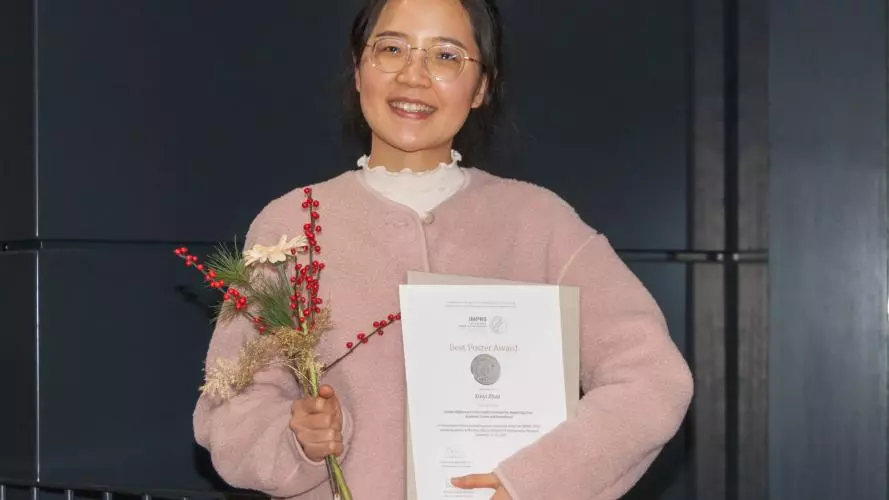 Xinyi Zhao holds the certificate of her award from the Max Planck Institute for Demographic Research