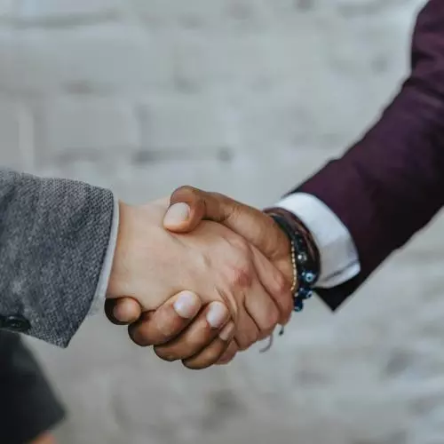Two people shake hands