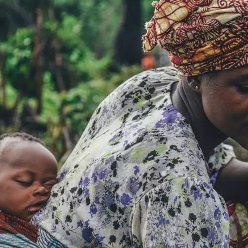 Image of a woman carrying a baby on her back
