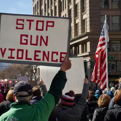 A man holds a sign saying 'stop gun violence' during a protest