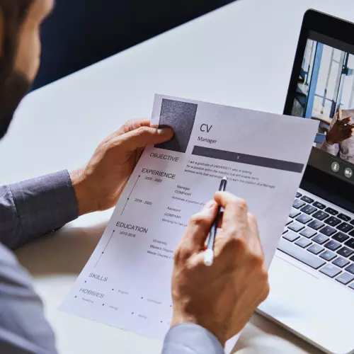 Man reviews a CV while talking online with a candidate 