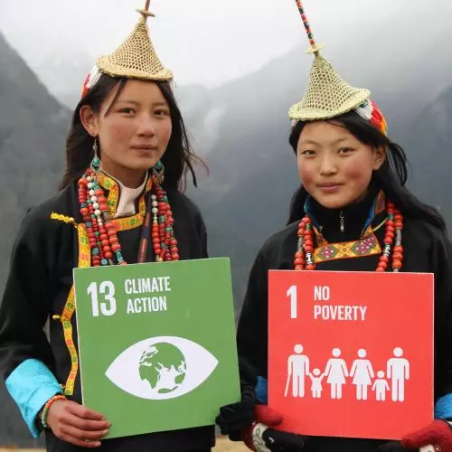 Two people holding signs which read '13 Climate Action' and '1 No Poverty'. Photo: UNDP Bhutan