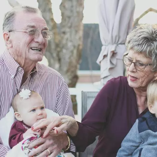 Image of an elderly couple sitting with their two young grandchildren 
