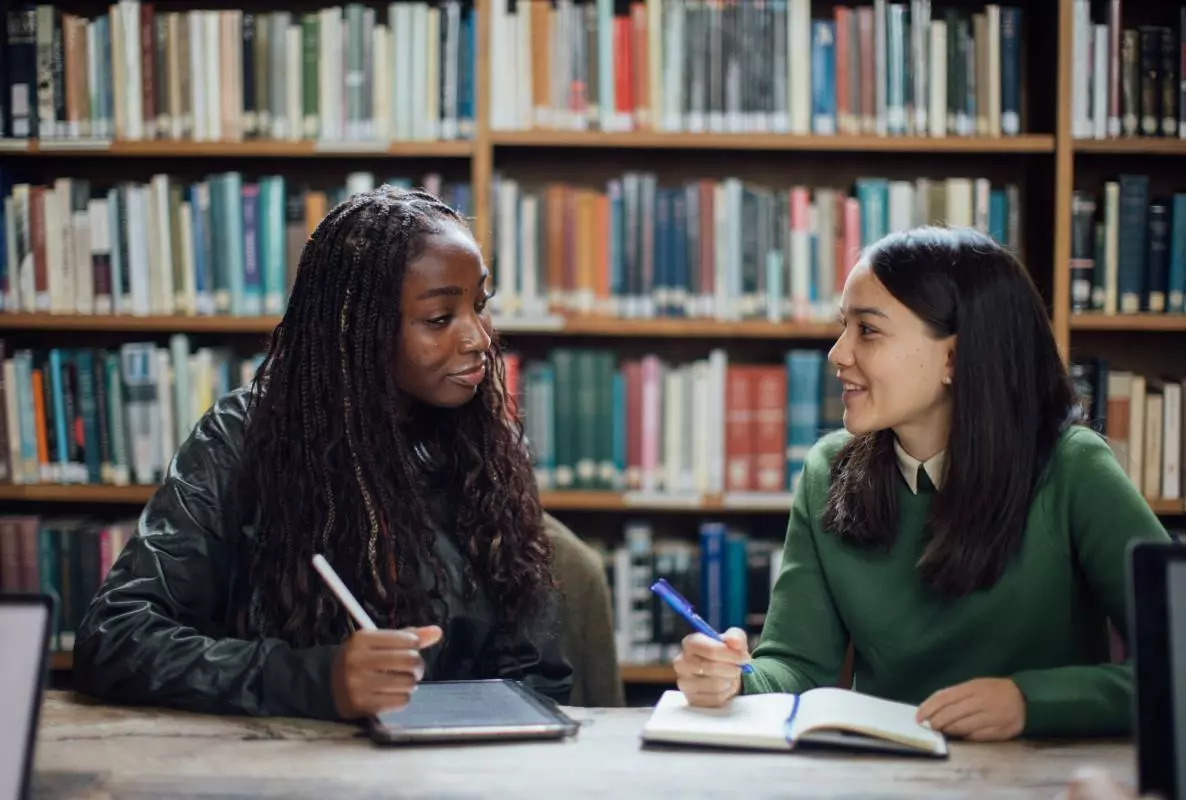 Image of two students in a library
