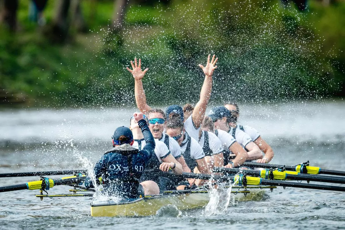 Image of boat of rowers celebrating after winning a race