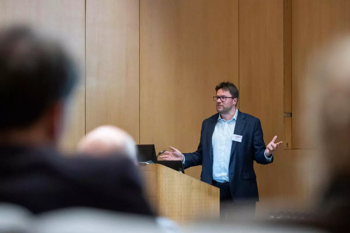 A speaker giving a lecture at the front of a room